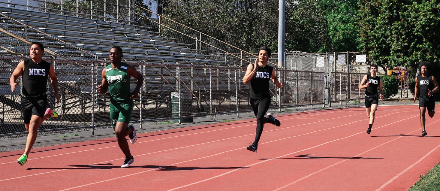 track team members running on track
